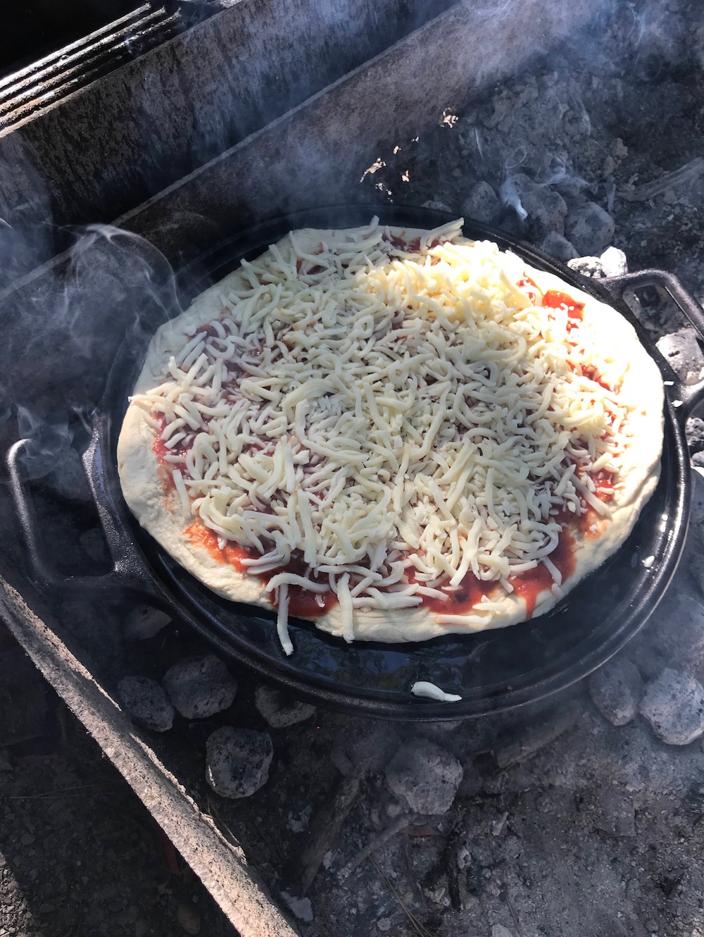 Pizza prepped and ready to cook over charcoal